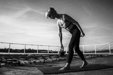 Güneşli günde kettlebell pilates pratik Kadın. 