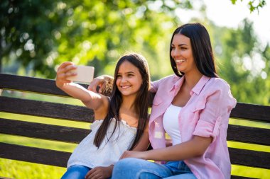 Mutlu bir aile birlikte parkta güzel vakit geçiriyoruz. Onlar selfie alıyor. 