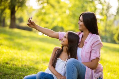 Mutlu bir aile birlikte parkta güzel vakit geçiriyoruz. Onlar selfie alıyor. 