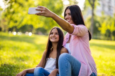 Mutlu bir aile birlikte parkta güzel vakit geçiriyoruz. Onlar selfie alıyor. 