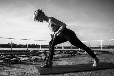 Güneşli bir günde elastik bant ile pilates egzersiz kadın. 