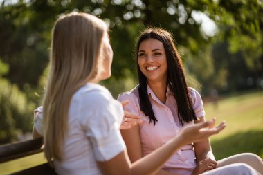 İki arkadaş parkta oturup konuşuyorlar..