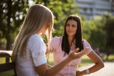 İki arkadaş parkta oturup konuşuyorlar..