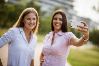 Mutlu iş arkadaşları tatilde parkta selfie çekiyor.