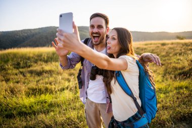 Mutlu çift dağda yürüyüş. Selfie çekiyorlar..