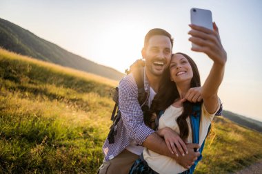 Mutlu çift dağda yürüyüş. Selfie çekiyorlar..