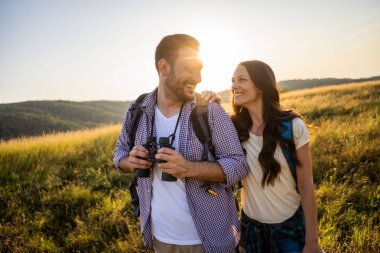 Mutlu çift dağda yürüyüş yapıyor. Doğayı dürbünle izliyorlar..