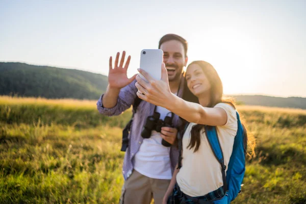 Mutlu çift dağda yürüyüş. Selfie çekiyorlar..