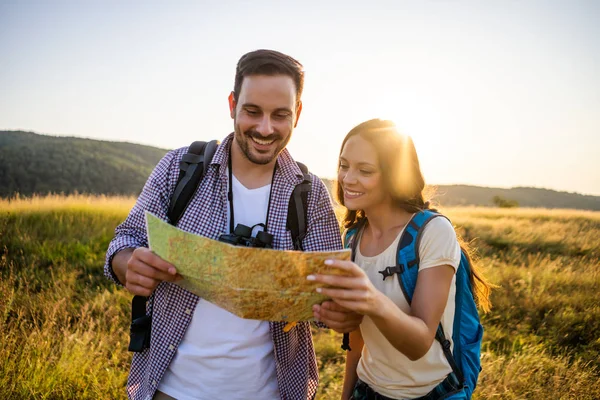 Mutlu çift dağda yürüyüş. Haritaya bakıyorlar..
