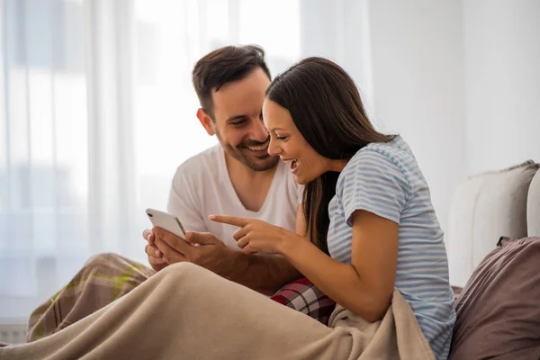 Joven Pareja Feliz Está Mirando Teléfono Inteligente Cama Por Mañana — Foto de Stock