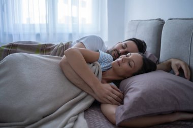 Genç çift yatakta yatıyor ve uyuyor..
