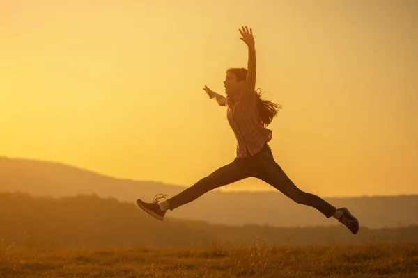 幸せな子供の自然の中で日没でジャンプ — ストック写真