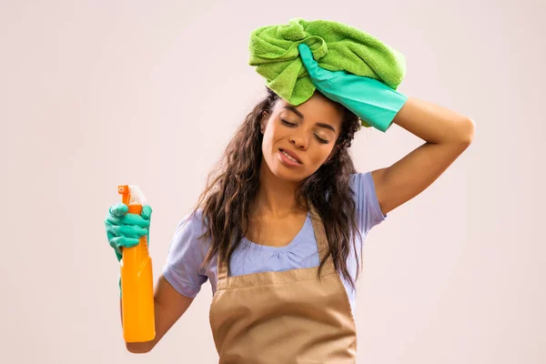 Portrait of african-american professional maid who is tired of cleaning.