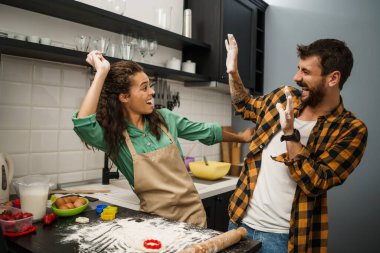 Mutfakta yemek yapan çok ırklı mutlu çift. Kurabiye yapıyorlar..