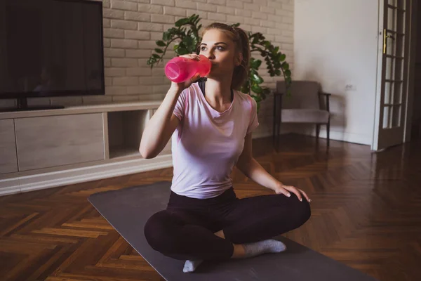 Ung Kvinna Tränar Pilates Och Yoga Övningar Hemma Hon Dricker — Stockfoto