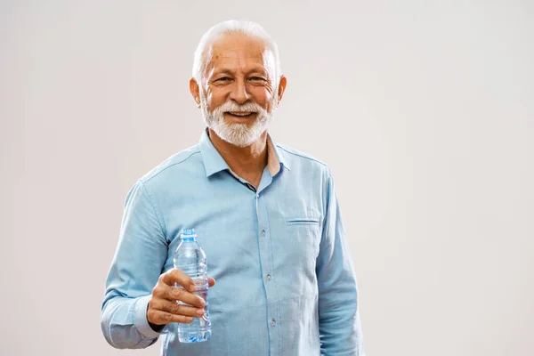 一个快乐的老人的画像 他拿着一瓶水 面带微笑 — 图库照片