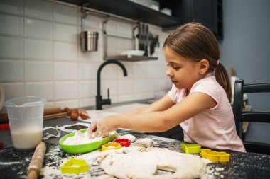 Hamurlu kaplama az, mutfakta kurabiye yapıyor..