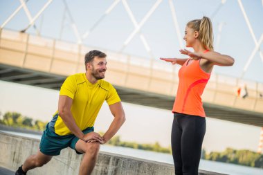 Genç çift dışarıda egzersiz yapıyor. Koşu için ısınıyorlar ve ısınıyorlar..
