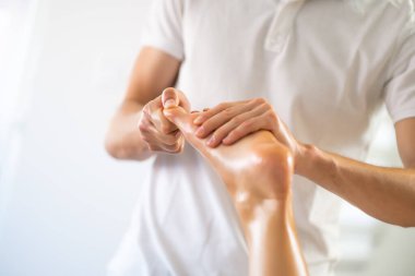 Profesyonel masör terapi masajı yapıyor. Kadın evinde masaj yaptırıyor. Genç kadın vücut masajı yaptırıyor..