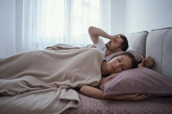 年轻夫妇躺在床上 早上醒来 — 图库照片