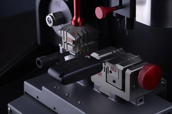 Anahtar lı anahtar kopyalama makinesinin yakın görünümü. Yinelenen makine yeni anahtar yapmak. Çilingir teması. Kesmek için boş anahtarlar. Siyah modern araba kapı açacağı. 