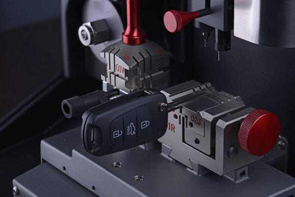 Закройте вид на копировальную машину с ключом. Дублирующая машина делает новый ключ. Тема слесаря. Бланширование ключей для резки. Черный открыватель дверей современного автомобиля
. 