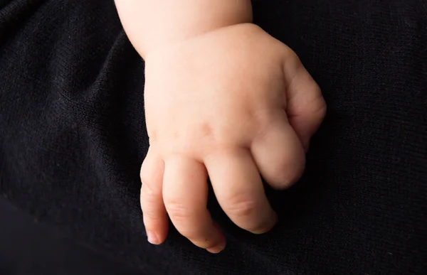 Hand neugeboren auf dunklem Hintergrund — Stockfoto
