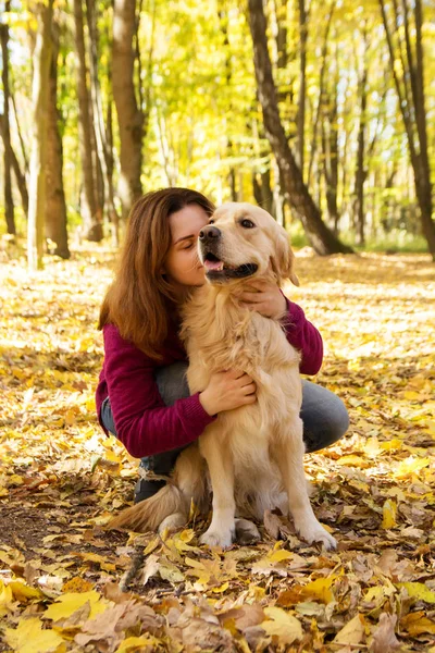 Schöne Frau mit Golden Retriever-Hund im Herbstpark — Stockfoto