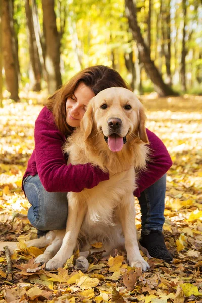 Güzel bir kadın ile bir golden retriever köpek sonbahar Park