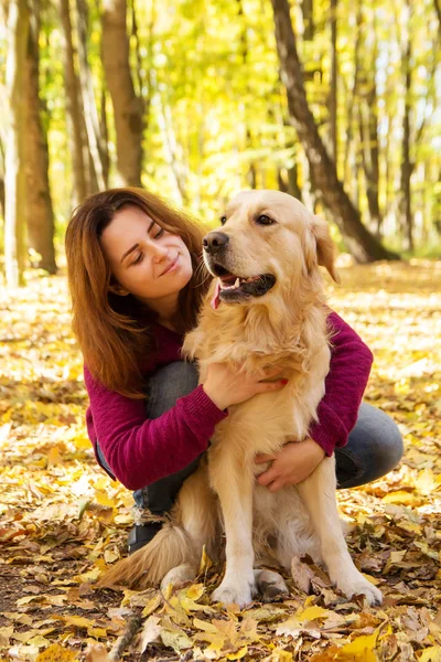 Schöne Frau mit Golden Retriever-Hund im Herbstpark — Stockfoto