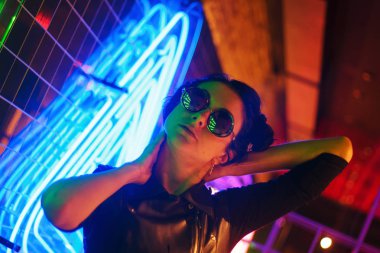 Kız ve neon ışıklarının sinematik gece portresi