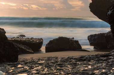 küçük plaj kayalar ve üzerinde kırma okyanus dalgaları
