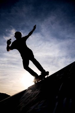 Yarım boru skate park dramatik hazzy gökyüzüne karşı paten sürme bir patenci silüeti