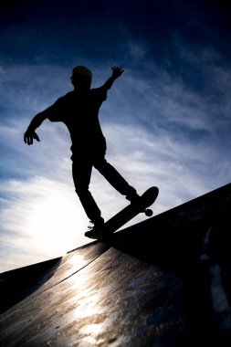 Yarım boru skate park dramatik hazzy gökyüzüne karşı paten sürme bir patenci silüeti