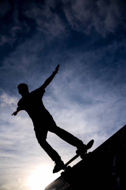 Yarım boru skate park dramatik hazzy gökyüzüne karşı paten sürme bir patenci silüeti