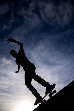 Yarım boru skate park dramatik hazzy gökyüzüne karşı paten sürme bir patenci silüeti