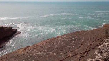  Okyanus dalgaları bir yaz gününde kayalara karşı kırılıyor