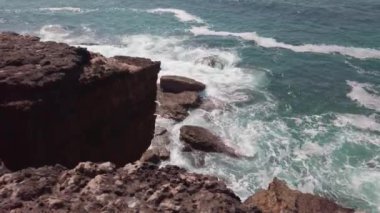  Okyanus dalgaları bir yaz gününde kayalara karşı kırılıyor