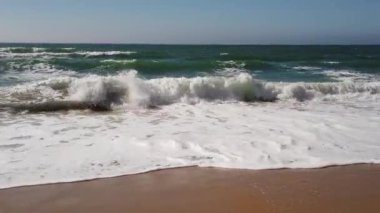 Portekiz'de bir plajda okyanus dalgaları kırılıyor