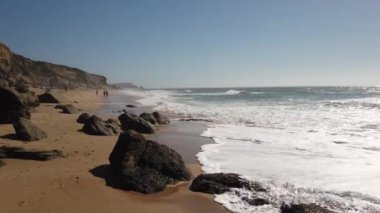 Portekiz'de bir plajda okyanus dalgaları kırılıyor