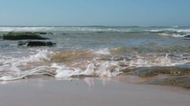 Dalgalar Portekiz 'de bir plajda kırılıyor