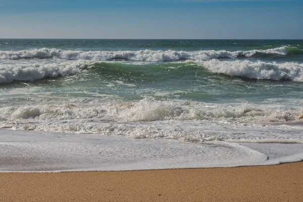  Sakin bir öğleden sonra kumsalda dalgalar kırılıyor.