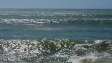 Dalgaları bekleyen sörfçüler