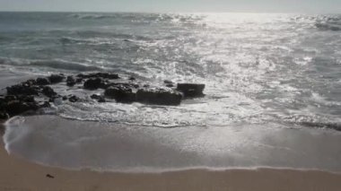  Sakin bir öğleden sonra kumsalda dalgalar kırılıyor.