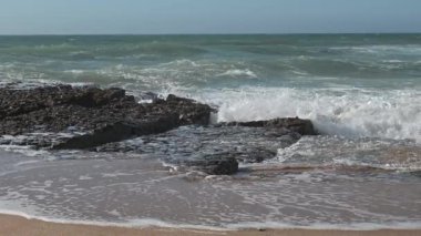  Sakin bir öğleden sonra kumsalda dalgalar kırılıyor.