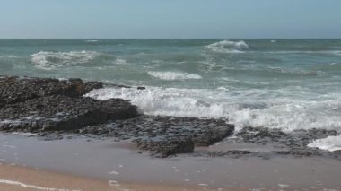  Sakin bir öğleden sonra kumsalda dalgalar kırılıyor.