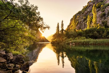 Nehir Cetina ağaçlar, kayalar ve yansıma bir su, güzel manzara, Omis, Hırvatistan ile Kanyon üzerinden günbatımı