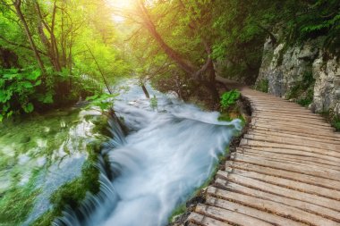 Plitvice Gölleri Milli Parkı, turistik güzergah üzerinde şelale, Hırvatistan, doğa güneşli arka plan boyunca ahşap döşeme