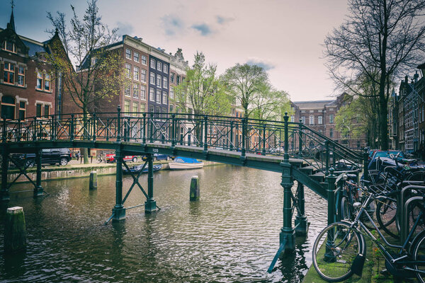 Canal in Amsterdam with small bridge and bicycles, Netherlands