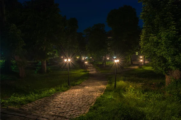 Eski Şehir Parkı ile kaldırım taşı, yeşillik ve fenerler gece